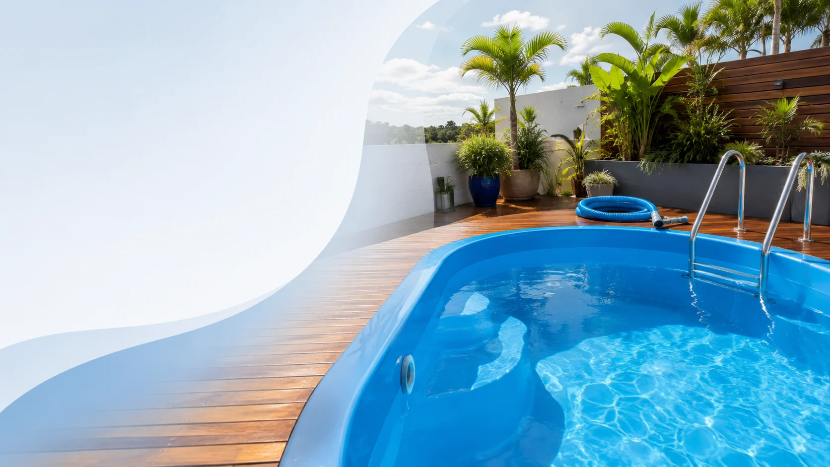Piscina de fibra azul vibrante recém-renovada, cercada por deck de madeira e plantas em área externa.